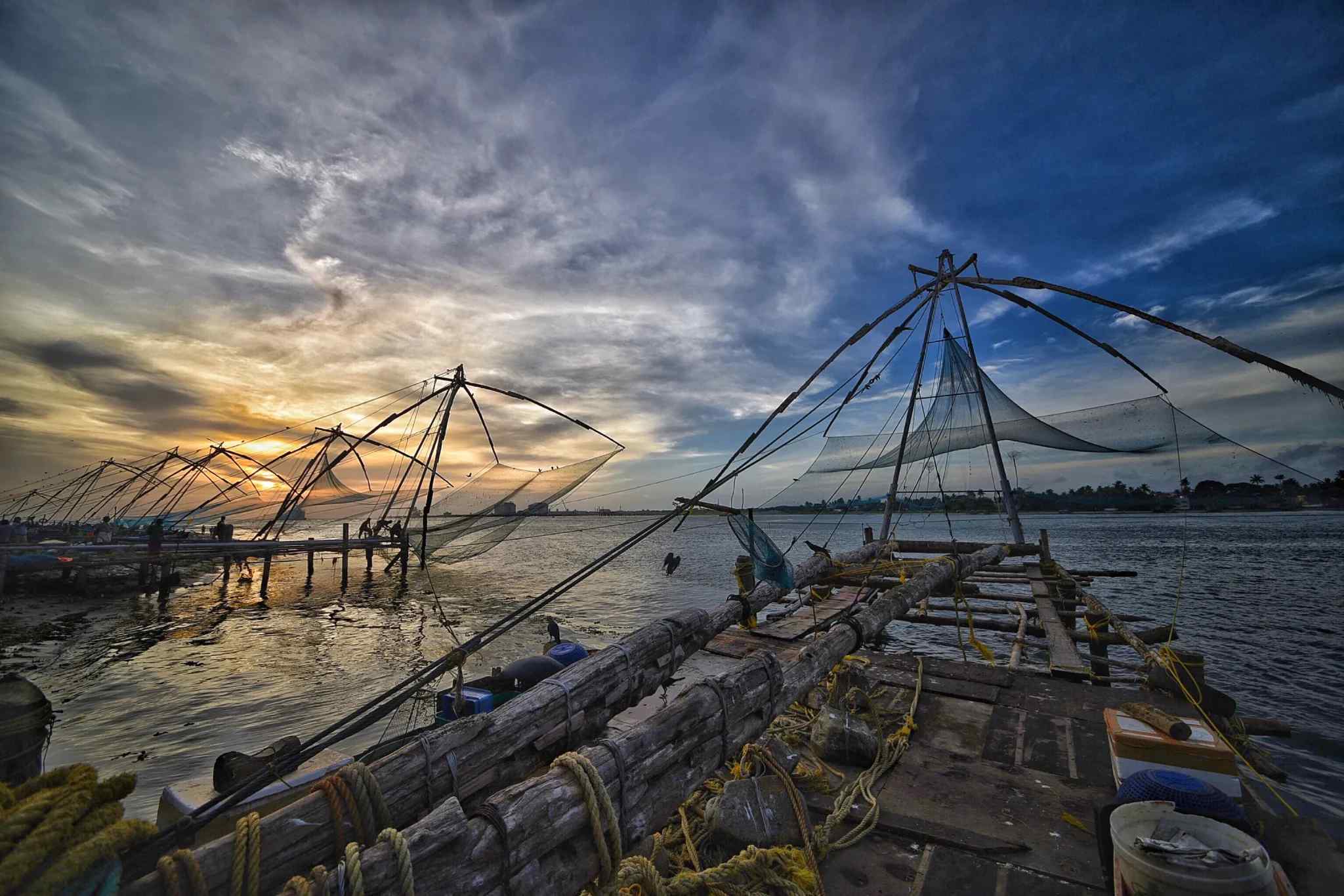 Scenic view of Kochi's coastline with Chinese fishing nets at sunset